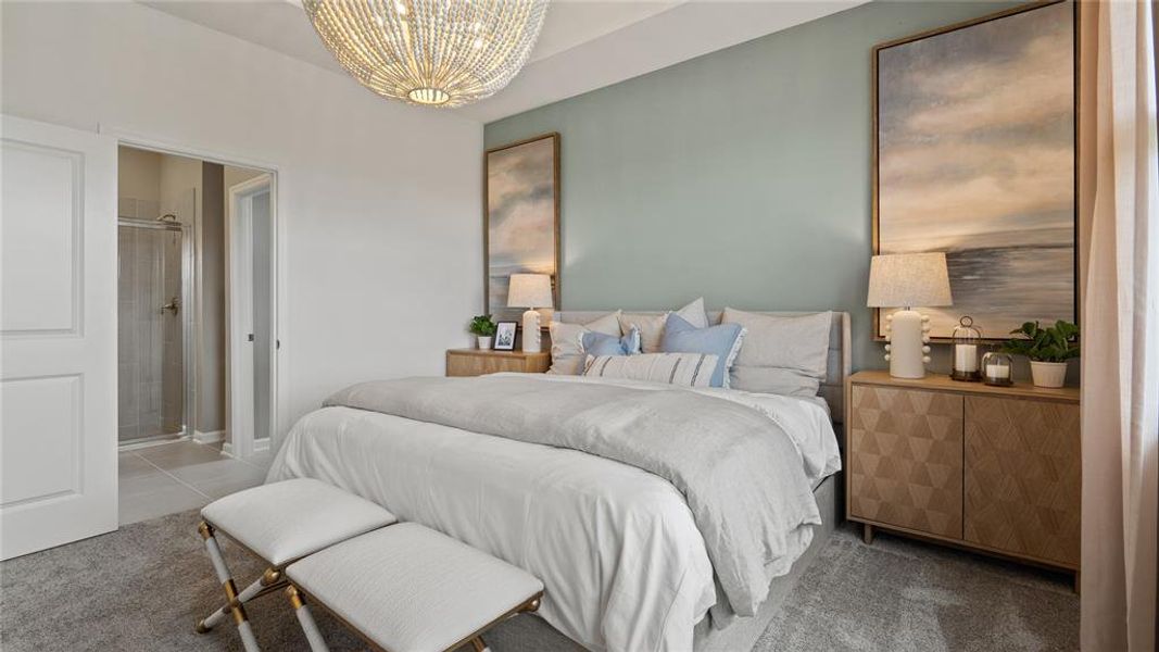 Carpeted bedroom with a chandelier and ensuite bathroom Carpeted bedroom with a chandelier and ensuite bathroom
