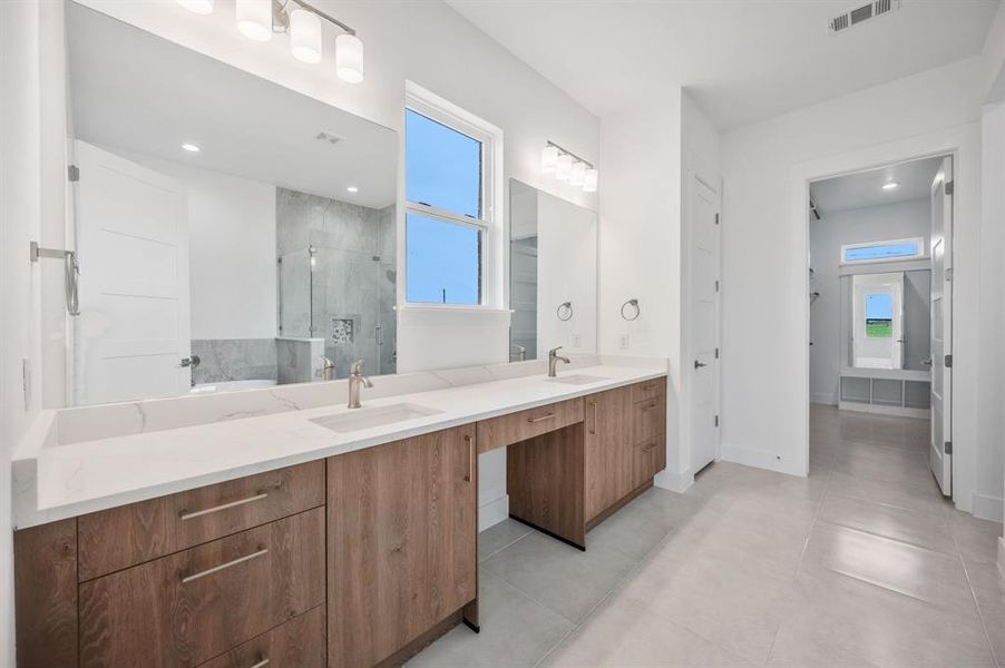 Bathroom with a sink, a stall shower, double vanity, and visible vents Bathroom with a sink, a stall shower, double vanity, and visible vents