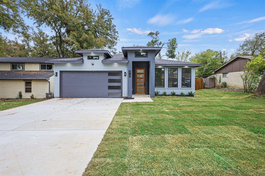 View of front of house featuring a front lawn and a garage