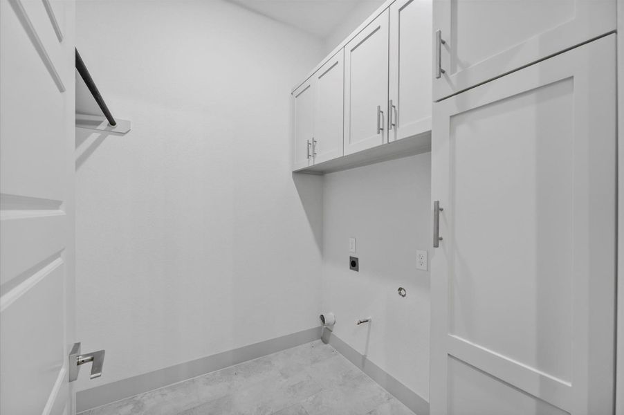 This photo shows a modern laundry room with white cabinetry, ample storage space, and hookups for a washer and dryer. The room has a clean, minimalist design with light-colored walls and flooring. This photo shows a modern laundry room with white cabinetry, ample storage space, and hookups for a washer and dryer. The room has a clean, minimalist design with light-colored walls and flooring.