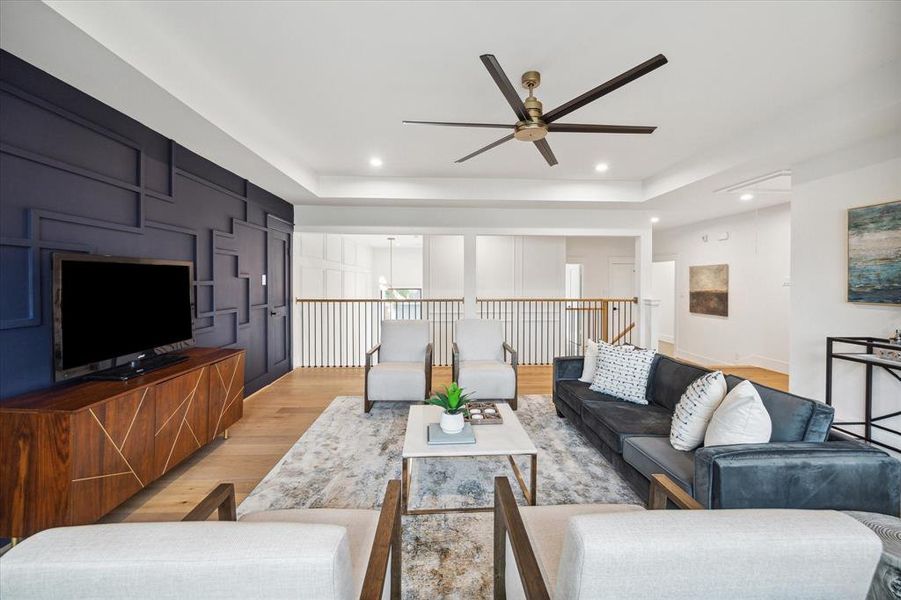 The spacious gameroom overlooks the first floor. It features a tray ceiling with recessed LED lighting , a 65 inch matte black and gold ceiling fan and hardwood floors.