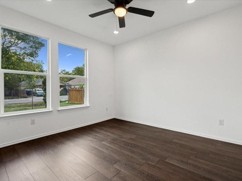 Unfurnished room with dark wood-type flooring and ceiling fan