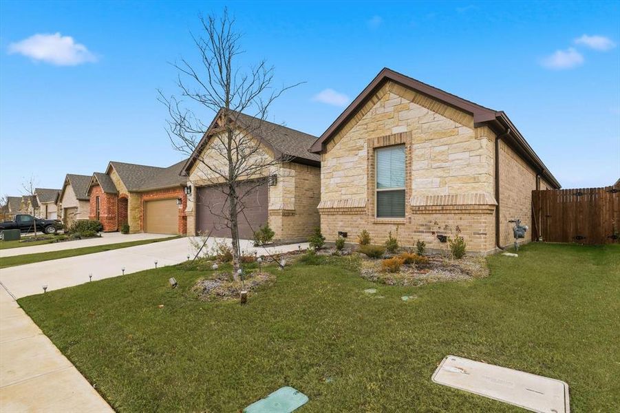 View of front facade featuring a garage, concrete driveway, stone siding, and brick siding