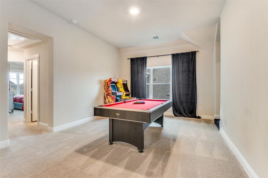 Recreation room with light colored carpet and pool table