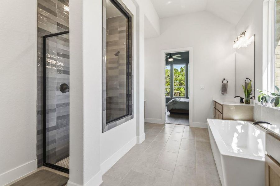 A well-lit primary bathroom features a spacious walk-in shower and a freestanding soaking tub.
