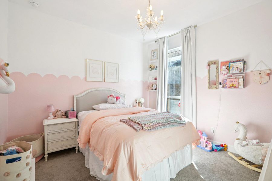 Carpeted bedroom featuring suspended lighting