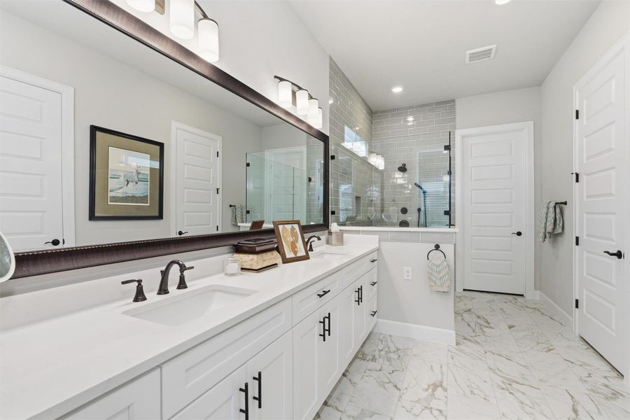 Large primary bath with long quartz-topped vanity, two sinks, walk-in shower, linen closet and walk-in closet Large primary bath with long quartz-topped vanity, two sinks, walk-in shower, linen closet and walk-in closet