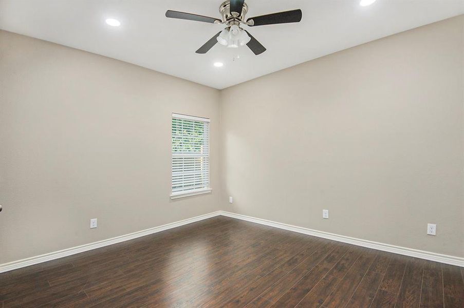 Empty room with dark wood-style floors, a ceiling fan, and recessed lighting
