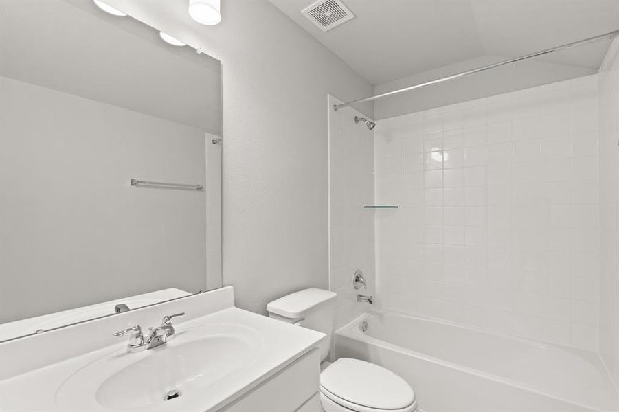 The secondary bath features tile flooring, white cabinetry and light countertops and a shower/tub combo. Perfect for accommodating any visiting family and friends.