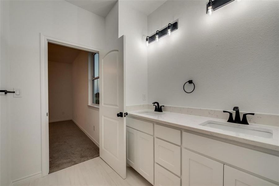 Full bathroom featuring double vanity and light carpet