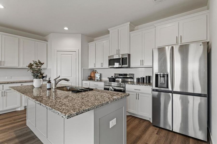 Kitchen with white cabinets, a kitchen island with sink, and appliances with stainless steel finishes