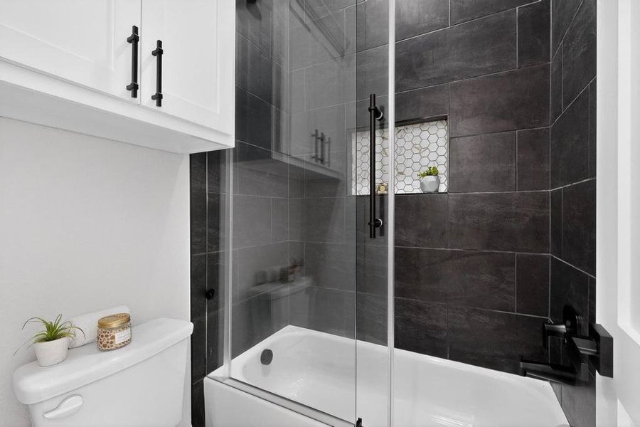 Full bathroom with bath / shower combo with glass door and toilet Full bathroom with bath / shower combo with glass door and toilet