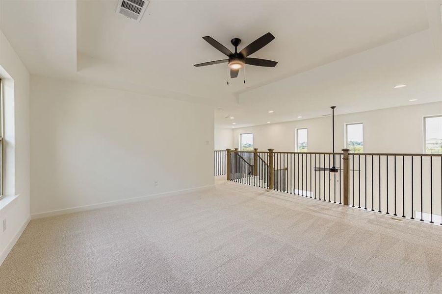 Empty room featuring light carpet, a ceiling fan, a tray ceiling, and recessed lighting Empty room featuring light carpet, a ceiling fan, a tray ceiling, and recessed lighting