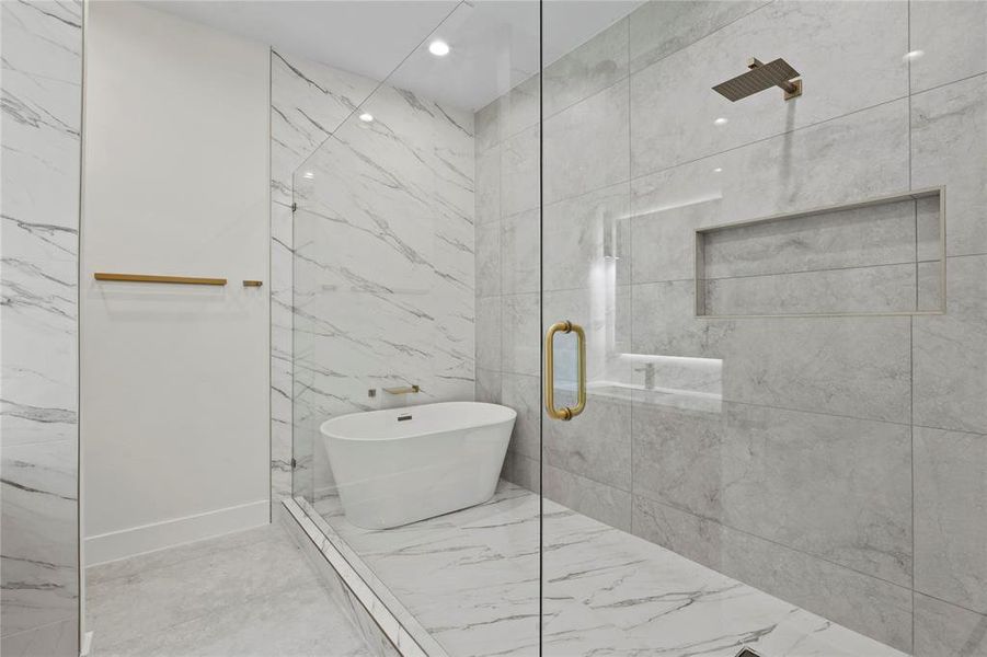 Bathroom with marble finish floor, a marble finish shower, a freestanding tub, and recessed lighting