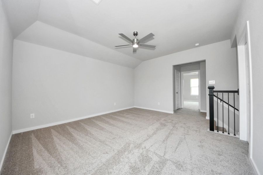 Come upstairs and relish a day of relaxation in this loft area! Ideal as an additional living space or game room, it boasts plush carpeting, high ceilings, custom paint, and windows that flood the area with abundant natural light. Sample photo of completed home with similar floor plan. Actual colors and selections may vary.
