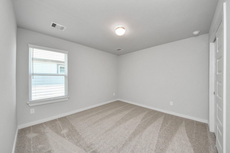 Generously sized secondary bedrooms featuring spacious closets, soft and inviting carpeting underfoot, large windows allowing plenty of natural light, and the added touch of privacy blinds for your personal retreat. Sample photo of completed home with similar floor plan. Actual colors and selections may vary.