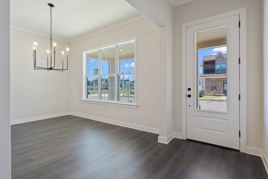 Unfurnished dining area featuring plenty of natural light, ornamental molding, dark wood-type flooring, and a chandelier Unfurnished dining area featuring plenty of natural light, ornamental molding, dark wood-type flooring, and a chandelier