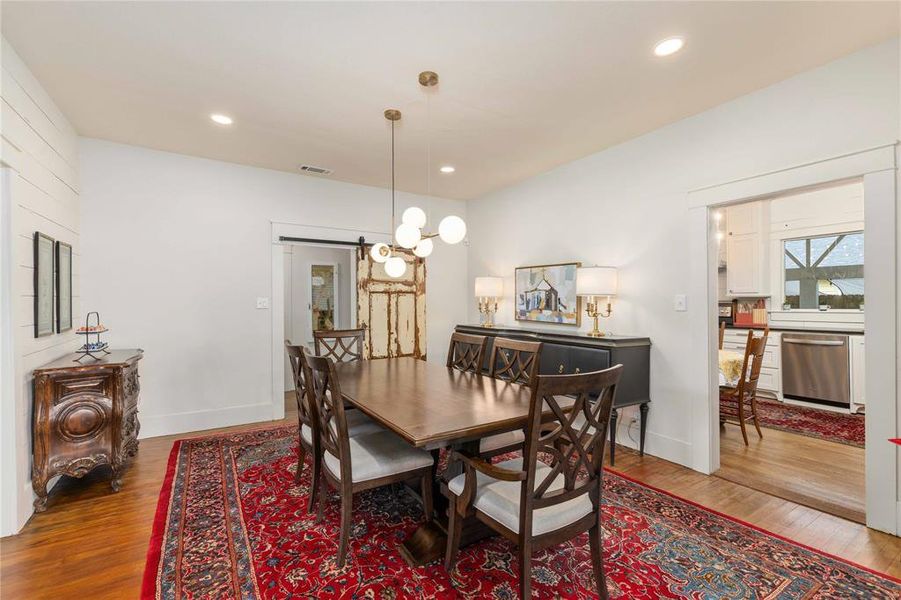 Dining area featuring a modern chandelier, recessed lighting, and wood-finish flooring