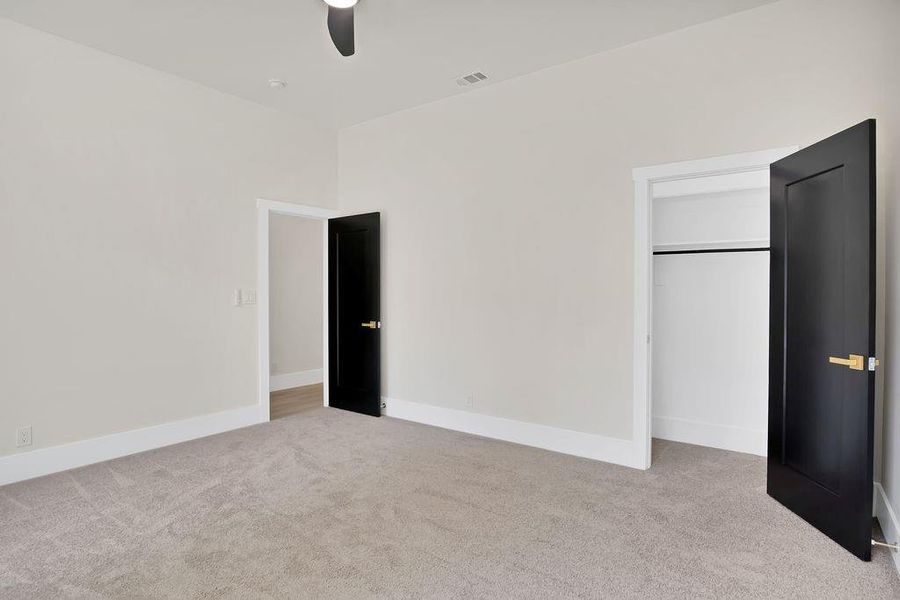 Unfurnished bedroom featuring light carpet, ceiling fan, and a closet