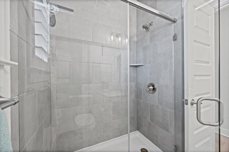 A well-appointed shower space featuring contemporary tile work and a glass enclosure.