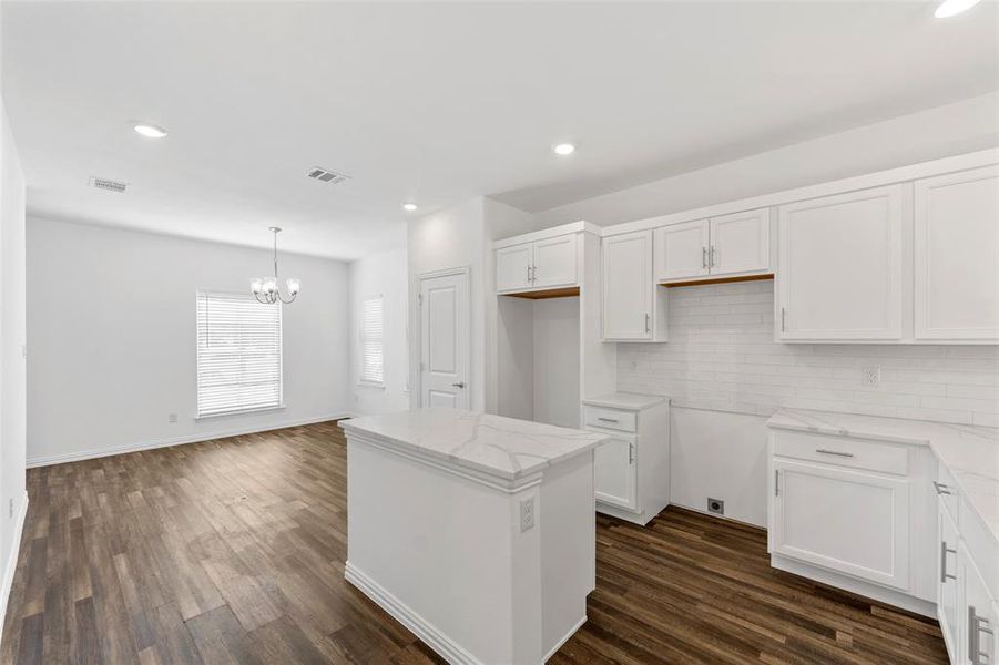 Kitchen featuring a notable chandelier, white cabinets, a kitchen island, and dark wood-type flooring