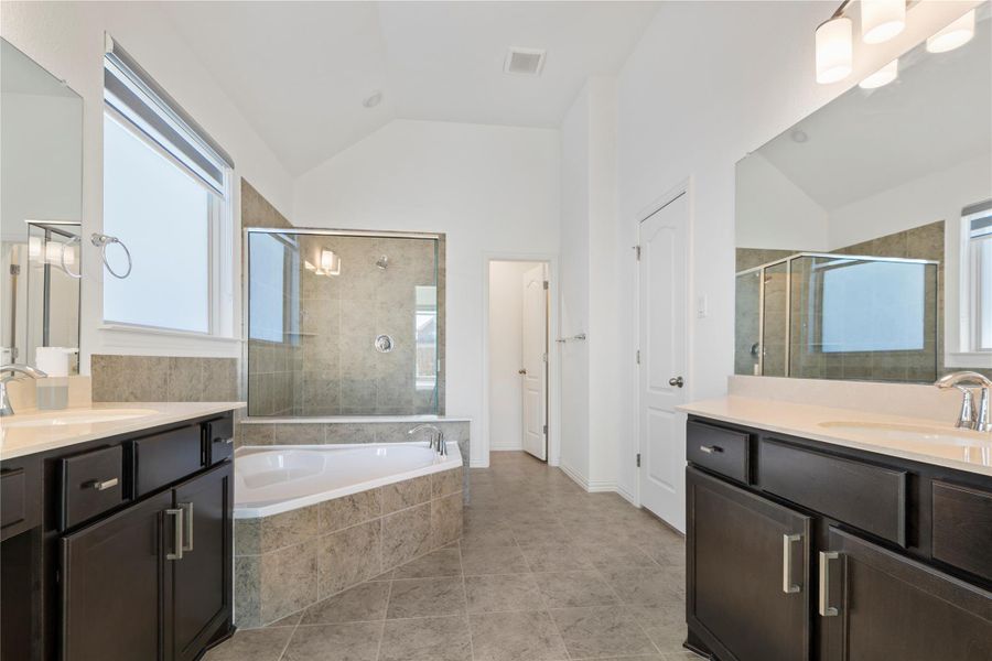 Luxurious bathing quarters feature dual vanities, a spacious walk-in shower, and a large soaking tub. Luxurious bathing quarters feature dual vanities, a spacious walk-in shower, and a large soaking tub.