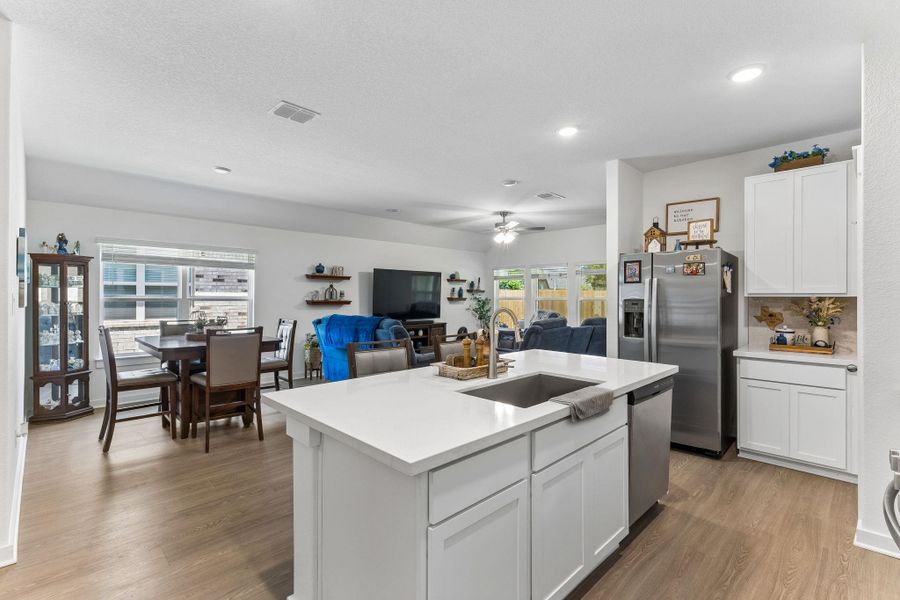 Kitchen island featuring a stainless steel sink opens to living dining for spacious open concept. Lots of natural light.