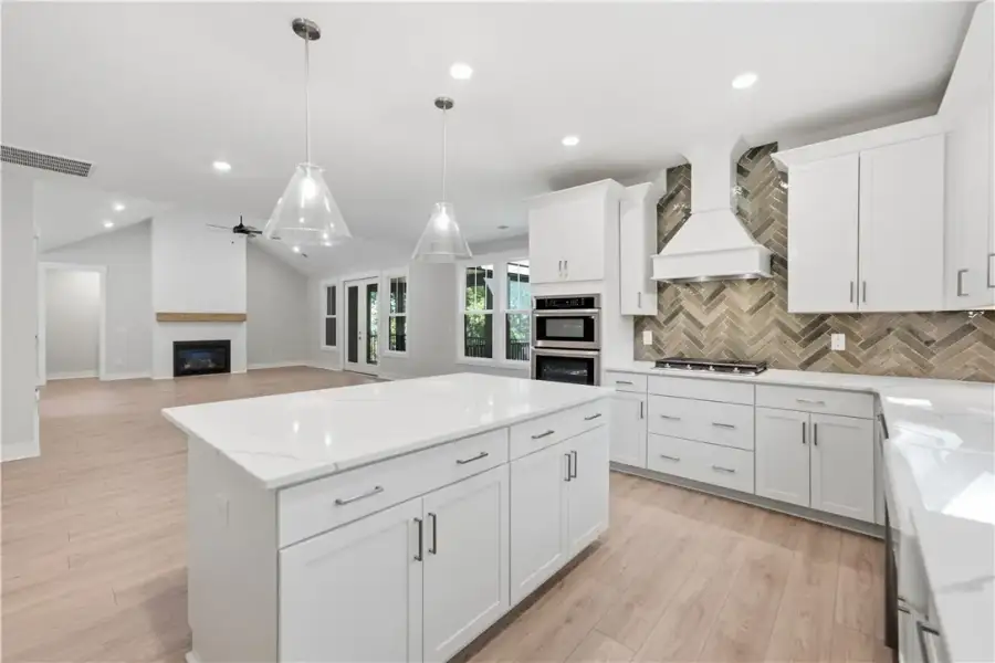 An open kitchen boasts a central island and seamle