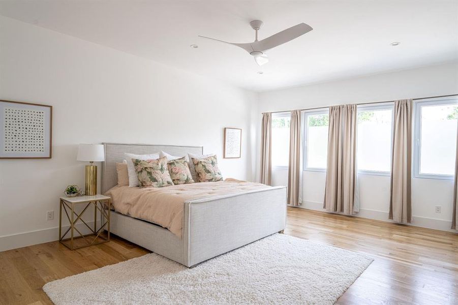 Bedroom with ceiling fan and light wood-type flooring Bedroom with ceiling fan and light wood-type flooring
