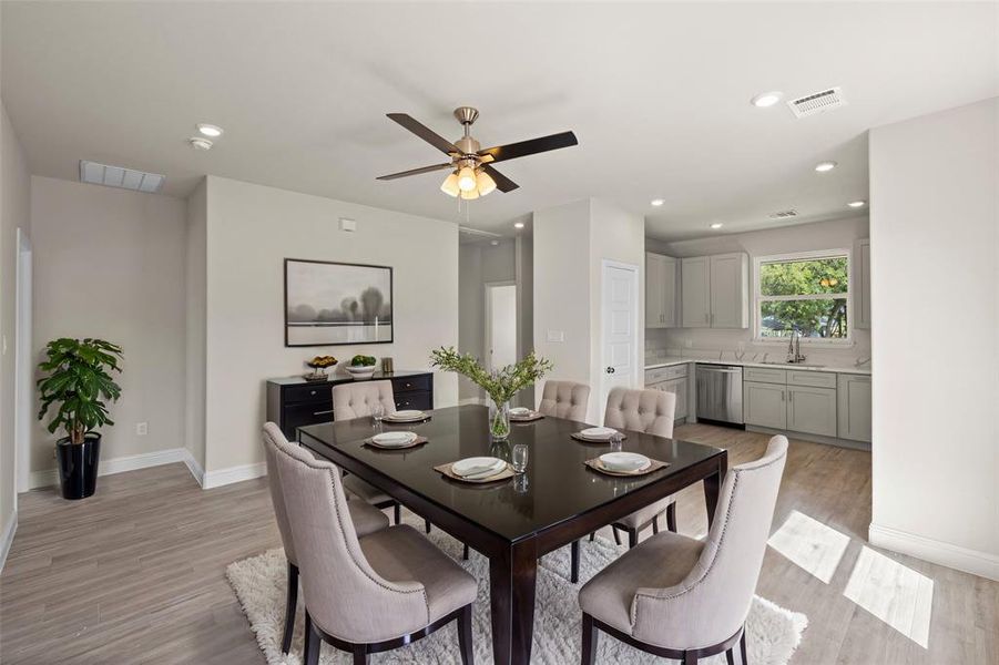 Dining room with sink, light wood-type flooring, and ceiling fan