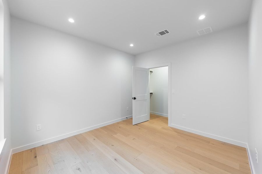 Empty room featuring light wood-style floors and recessed lighting
