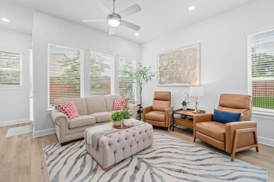 Living area with a ceiling fan, recessed lighting, light wood-style flooring, and a wealth of natural light Living area with a ceiling fan, recessed lighting, light wood-style flooring, and a wealth of natural light