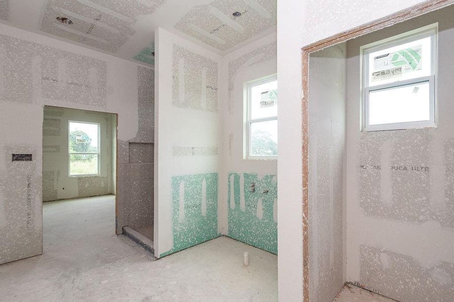 Bright and airy unfinished interior primary bathroom with large windows, ready for customization to suit your style. Bright and airy unfinished interior primary bathroom with large windows, ready for customization to suit your style.