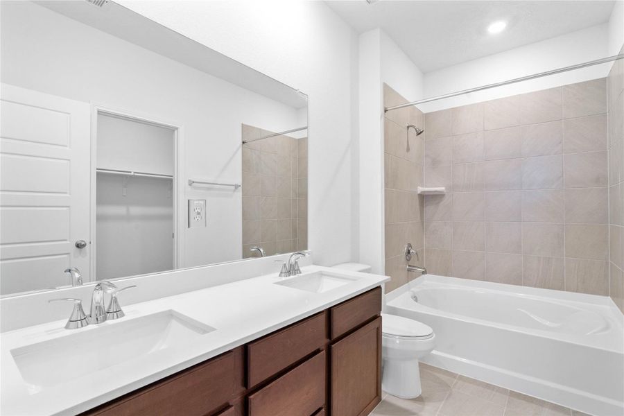 This stunningly updated primary bathroom is truly move-in ready! It features white stained cabinetry with light countertops, dual sinks, a large mirror, high ceilings, custom paint, and sleek modern finishes throughout.
