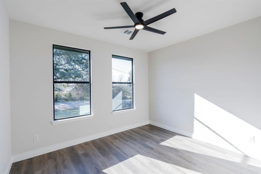 Bedroom with ceiling fan, a wealth of natural light, and hardwood / wood-style floors