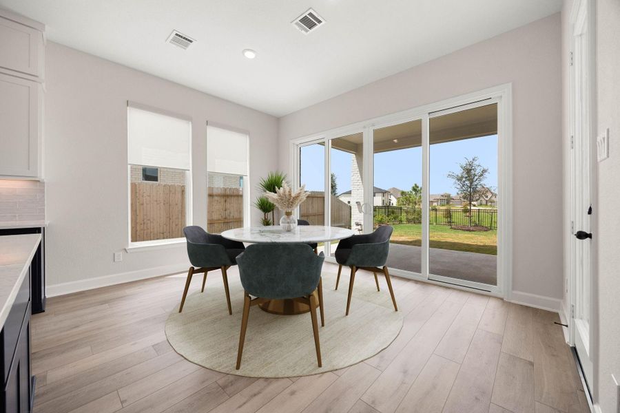 Bright and airy breakfast room positioned just off the kitchen for casual everyday dining. This sun-drenched space features massive sliding glass doors that provide seamless access to the covered back patio and frame open views of the expansive green backyard. Modern wide-plank flooring, recessed ceiling lights, and two additional side windows equipped with privacy shades make this the perfect inviting spot for morning coffee or casual family meals. *Virtually Staged Bright and airy breakfast room positioned just off the kitchen for casual everyday dining. This sun-drenched space features massive sliding glass doors that provide seamless access to the covered back patio and frame open views of the expansive green backyard. Modern wide-plank flooring, recessed ceiling lights, and two additional side windows equipped with privacy shades make this the perfect inviting spot for morning coffee or casual family meals. *Virtually Staged