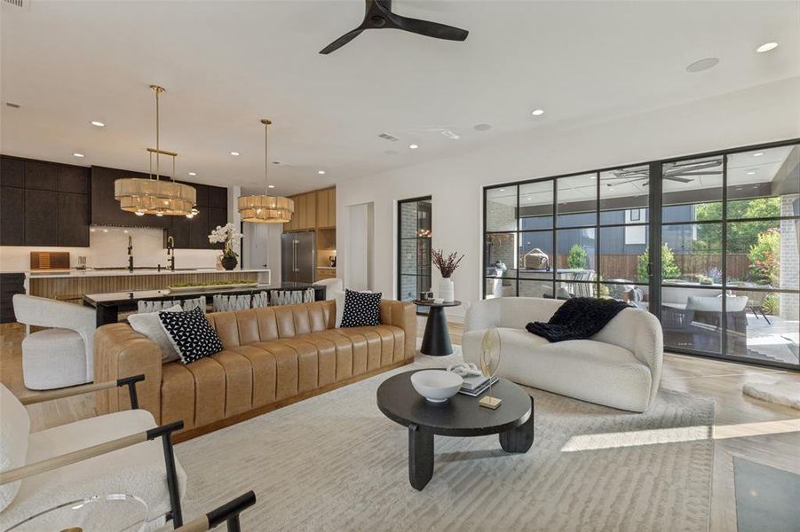 Open-concept living space featuring wood-finish flooring, recessed lighting, and a contemporary ceiling fan Open-concept living space featuring wood-finish flooring, recessed lighting, and a contemporary ceiling fan