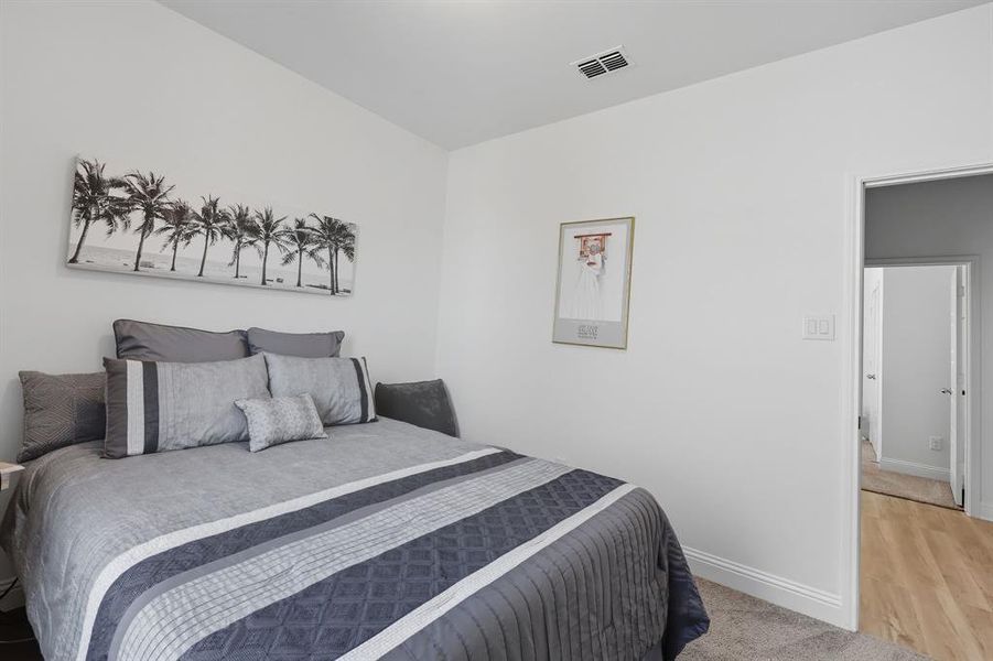 Bedroom with light colored carpet and light wood-style floors Bedroom with light colored carpet and light wood-style floors