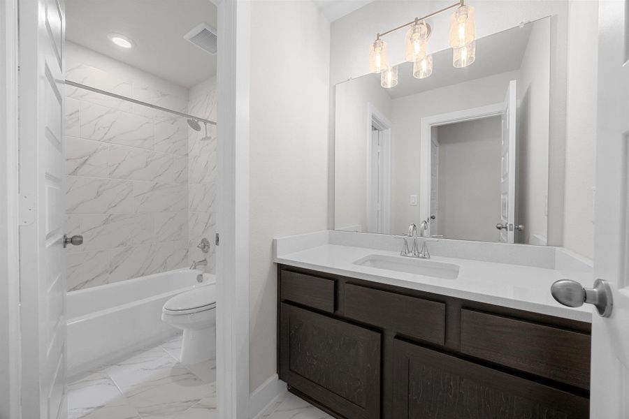 Bathroom featuring marble look tile flooring, vanity,  shower combination, and recessed lighting