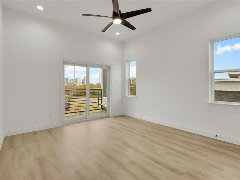 Unfurnished room featuring plenty of natural light, ceiling fan, and light wood-type flooring