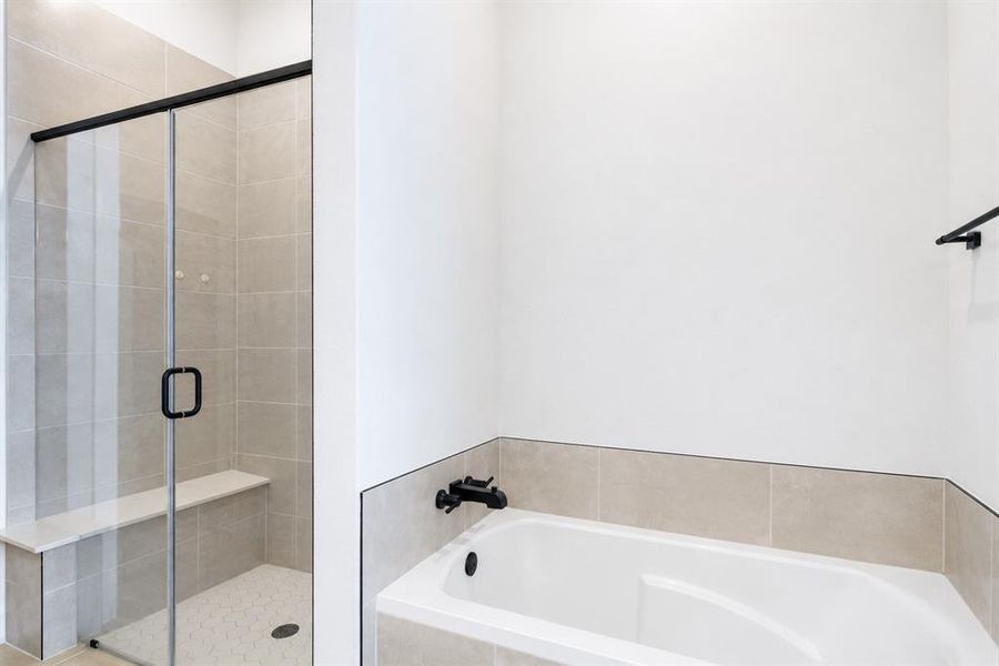Bathroom featuring a built-in tub with matte black fixtures, a tiled surround, and a glass-enclosed shower with a bench