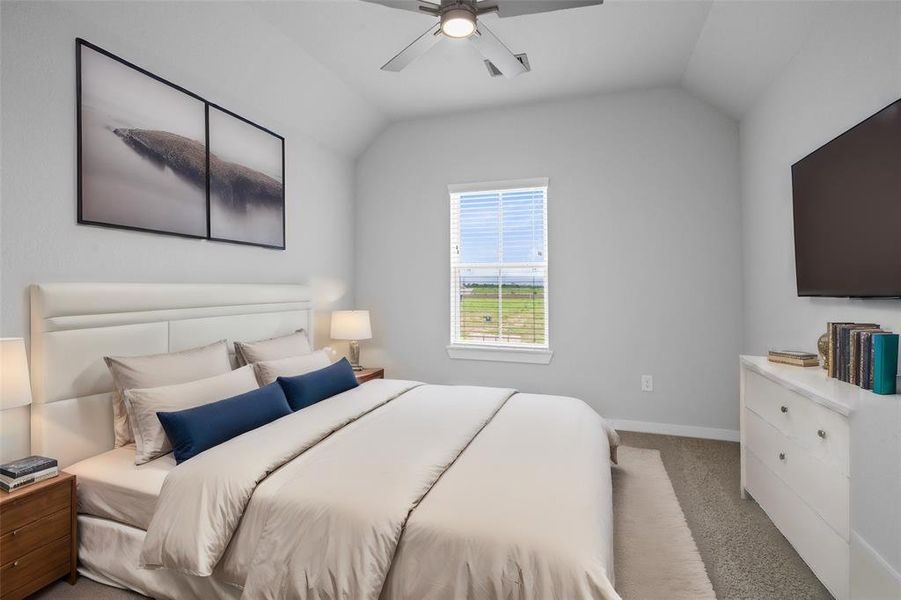 Secondary bedroom features plush carpet, custom paint, ceiling fan with lighting and a large window with privacy blinds.