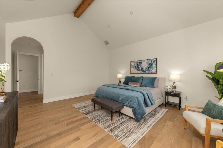 Bedroom featuring arched walkways and light wood-style floors