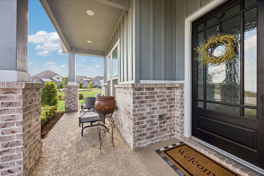 Covered front porch framed by painted siding and brick creates a warm, architectural entry with clean lines and recessed lighting overhead. Glass pane mahogany front door allows natural light to filter inside while maintaining a sense of privacy. Covered front porch framed by painted siding and brick creates a warm, architectural entry with clean lines and recessed lighting overhead. Glass pane mahogany front door allows natural light to filter inside while maintaining a sense of privacy.