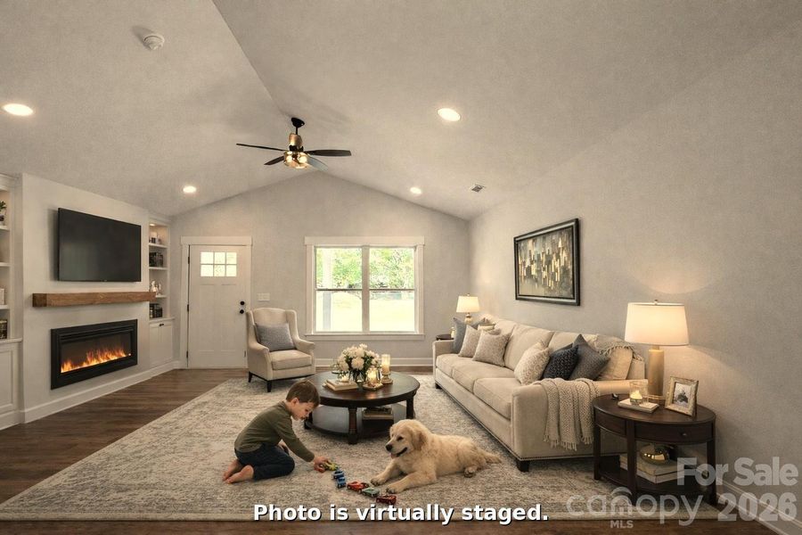 Den & open plan with cathedral ceilings & virtual staging with furniture, tv, mantel and built ins. Used to show the home owner what you can do with the Den.