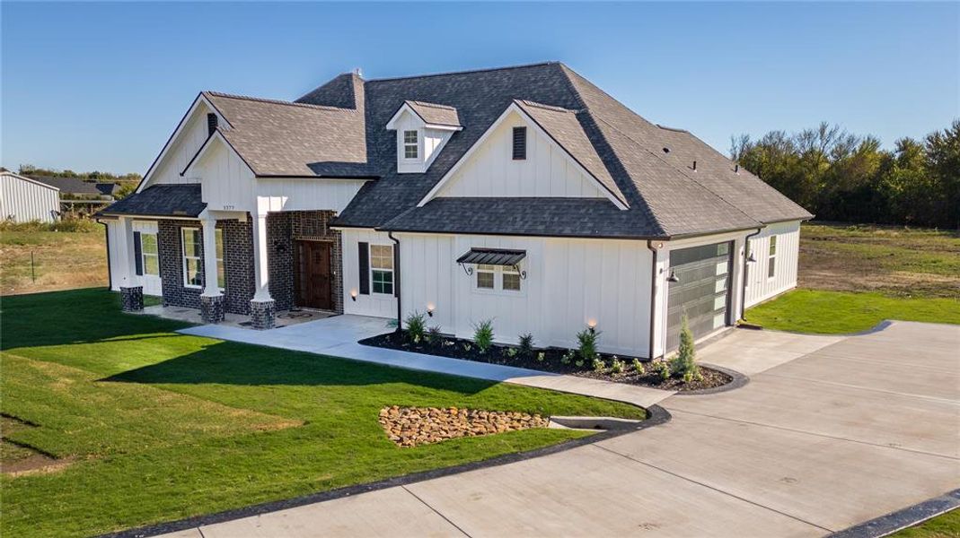 Modern farmhouse style home with a garage and a front lawn