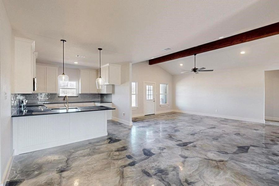 Kitchen with plenty of natural light, dark countertops, a sink, and white cabinets