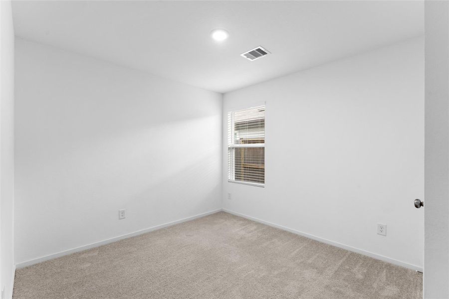 Comfortable secondary bedroom with space for furniture and personal touches.