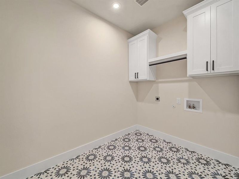 Clothes washing area with washer hookup, electric dryer hookup, hookup for a gas dryer, and cabinets