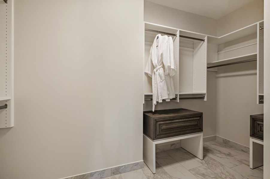 Ample storage solutions await in this walk-in closet, featuring versatile shelving and drawer units.